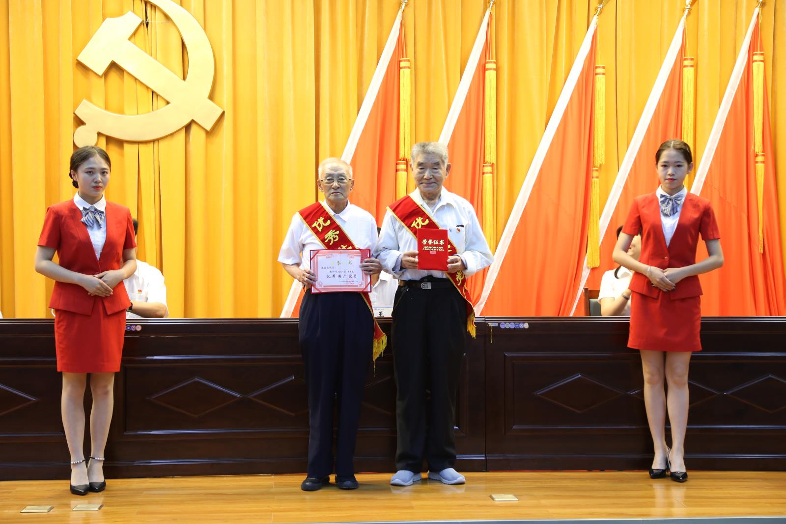 受表彰的优秀共产党员离退休职工:吴国安、张国忠上台领取奖杯和证书