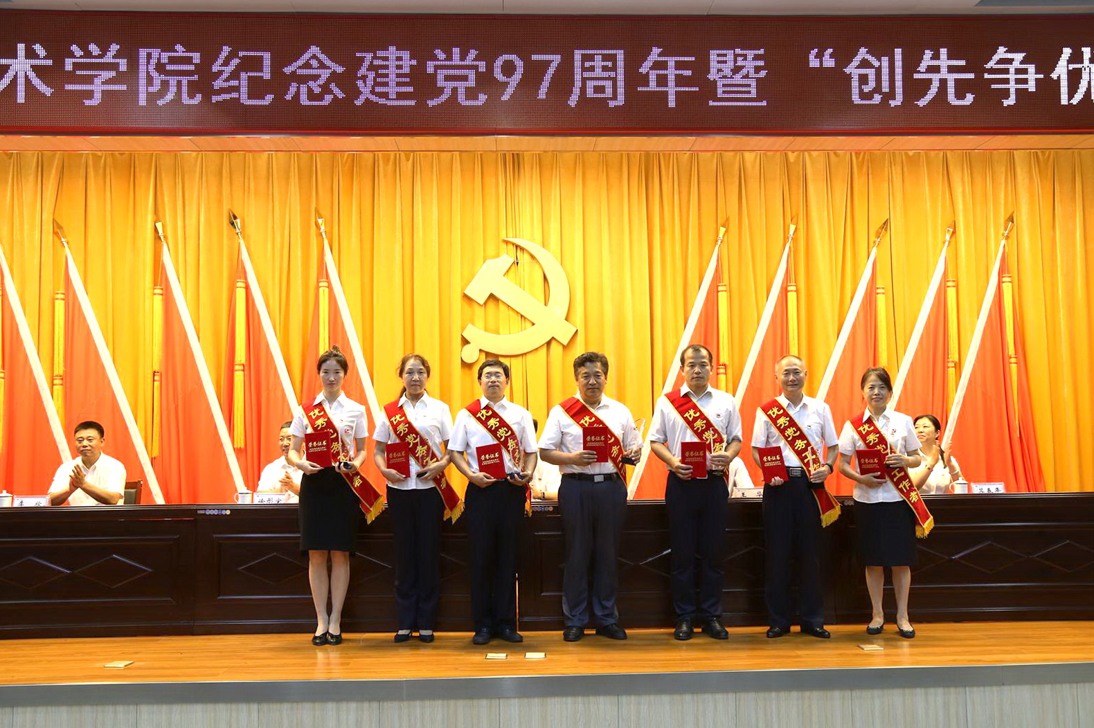 受表彰的优秀党务工作者上台领取奖杯和证书