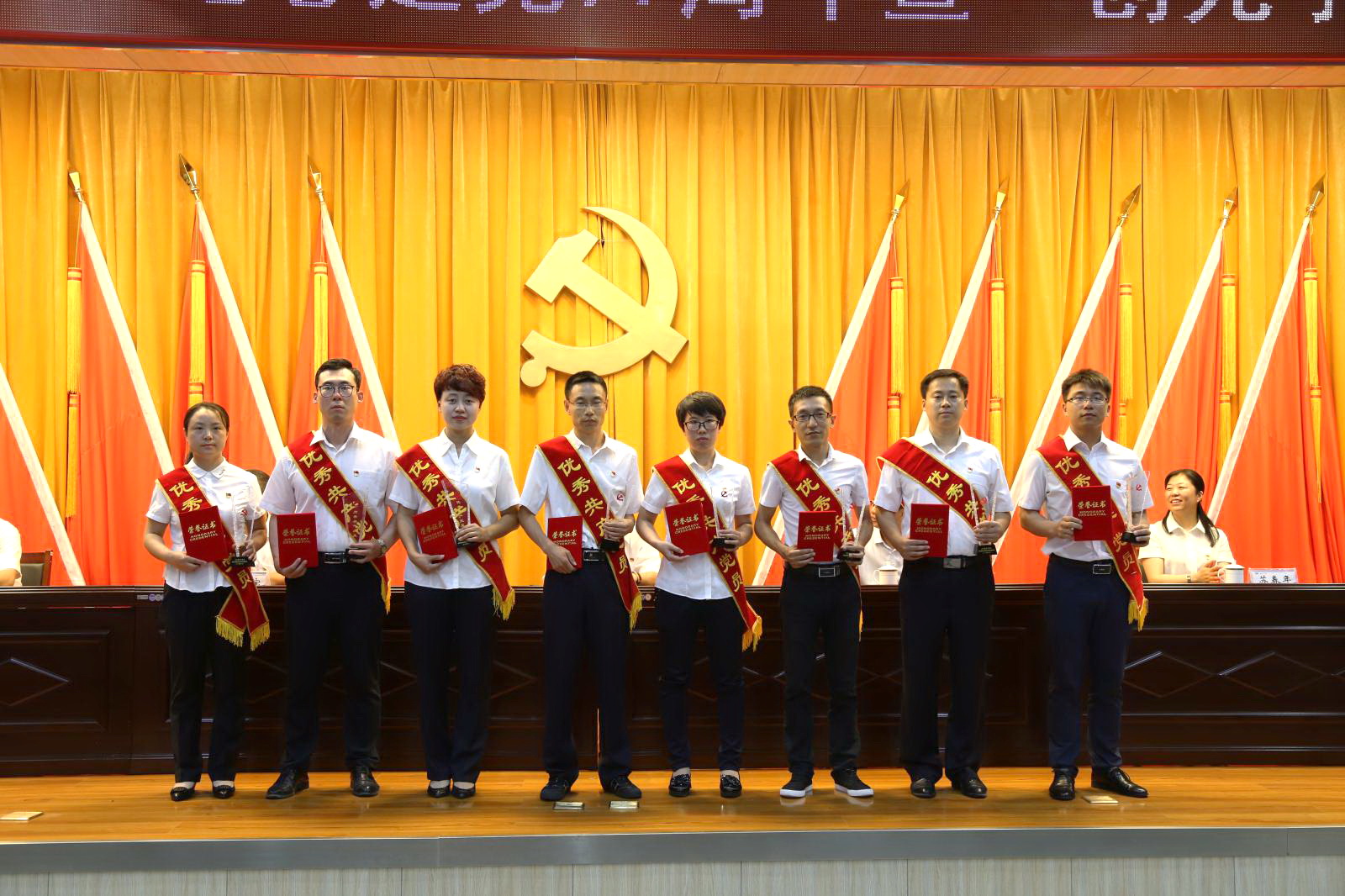 受表彰的优秀共产党员上台领取奖杯和证书